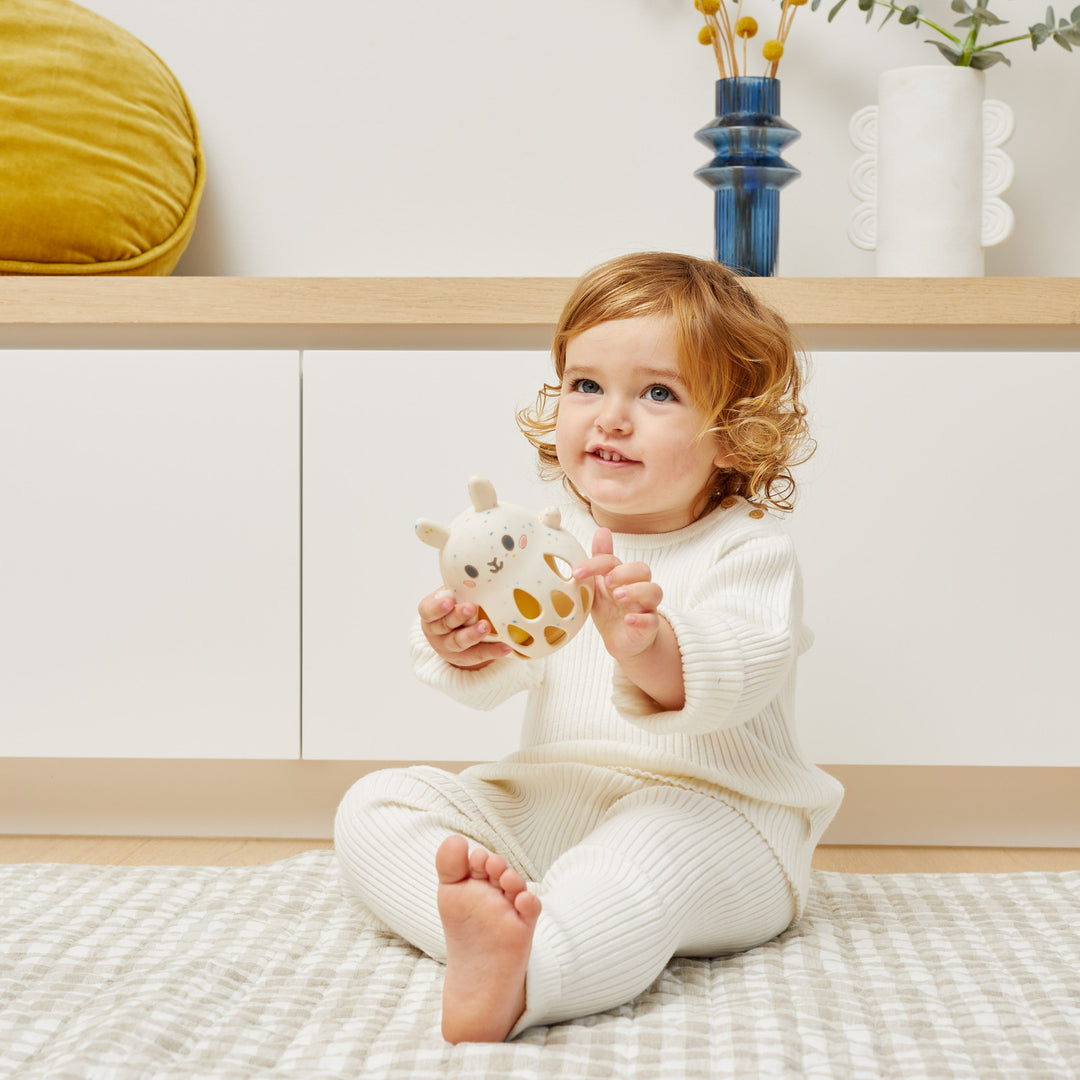 Baby holding a silicone baby rattle toy